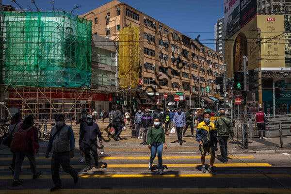 پوشیدن ماسک صورت در هنگ کنگ در روز سه شنبه.  دو سال پس از اعلام همه‌گیری، این شهر بدترین شیوع خود را تجربه می‌کند.